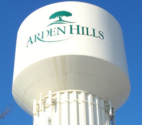 White Arden Hills water tower with green letters and a tree logo on top