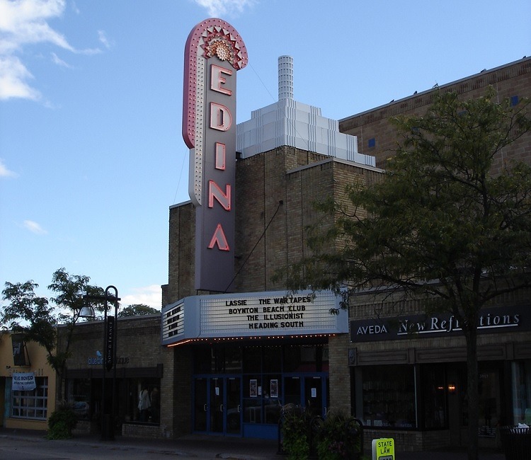 Outside of the Edina movie theatre with an edina sign on the sign and a clear sky.